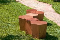 three wooden stools sitting on top of green grass