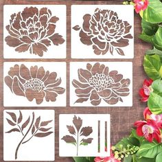 four flower stencils are shown on a wooden surface with flowers in the background