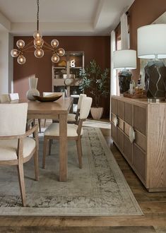 a dining room table with chairs and a rug on the floor in front of it