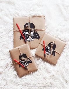 four wrapped presents with darth vader faces on them, tied in twine