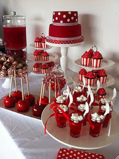 a table topped with lots of red and white desserts