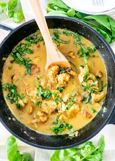 a skillet filled with chicken and spinach in a creamy broth, ready to be eaten