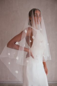 a woman wearing a white veil with flowers on it