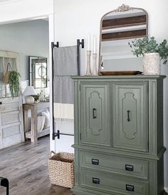 an old dresser is painted green with white trim