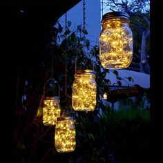 mason jars filled with lights hanging from a tree