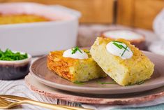 two pieces of cornbread with sour cream on top and green garnishes