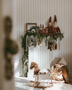 a rocking horse in front of a fireplace with christmas decorations on it's mantle