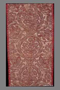 an old red and white paisley pattern on a black background