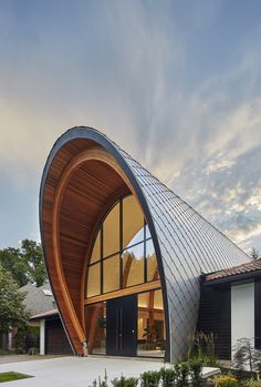 an unusual house with a curved roof and large windows