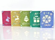 four different colored christmas cards with snowflakes on them