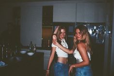 two young women standing in a kitchen next to each other