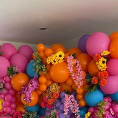 an arrangement of balloons and flowers on the wall