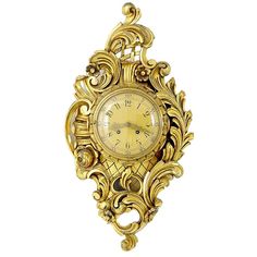 an ornate gold clock hanging on the wall