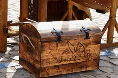 an old wooden chest with graffiti on it sitting in the middle of a cobblestone street