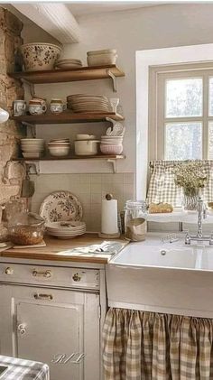 a kitchen filled with lots of dishes on top of a counter next to a window