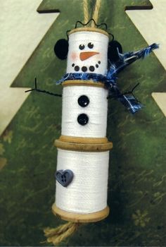 a snowman made out of twine and buttons on a christmas tree ornament