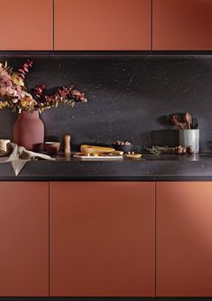 the kitchen counter is covered with various items and utensils, including an orange vase