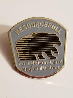 a silver and gold colored badge with the words, resourceful fort nelson - hard regional district