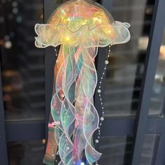 a light up jellyfish is on display in front of a glass door with lights