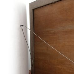 a person holding onto a door with a string attached to it