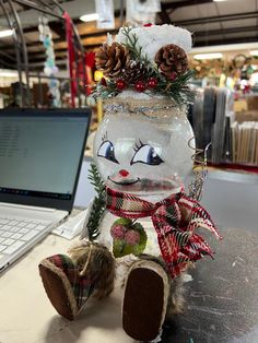 a snowman sitting on top of a table next to a laptop