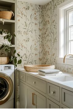 a washer and dryer in a small room with floral wallpaper on the walls