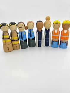 a group of wooden people standing next to each other in front of a white background