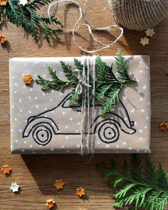 a wrapped present sitting on top of a wooden table next to christmas decorations and twine