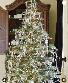 a white christmas tree with lights and ornaments