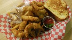 a basket filled with fried chicken and french fries next to ketchup on a table