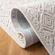 a close up of a rug on the floor with a wooden floor in the background