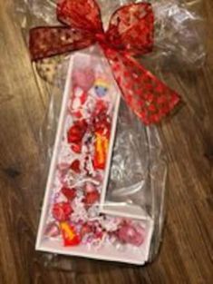 the letter i is made out of candy and wrapped in cellophane with a red bow