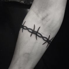 a black and white photo of a person's foot with barbed wire on it