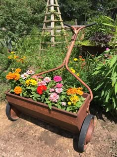 a wheelbarrow filled with colorful flowers in a garden next to a wooden ladder