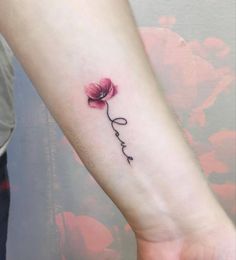 a small pink flower with the word love tattooed on it's left forearm and wrist