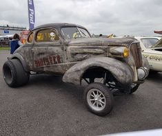 an old car is parked in a parking lot