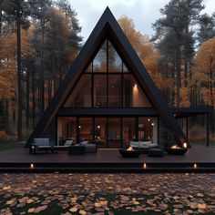 a house in the woods is lit up at night with candles on the floor and windows