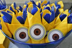 a bowl filled with blue and yellow paper napkins covered in googly eyeballs