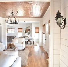 an instagram photo of a living room with white couches and wood ceilinging