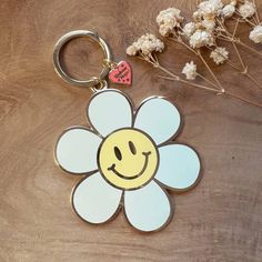 a flower shaped keychain with a smiley face on it