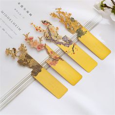 five pieces of yellow paper with flowers and birds on them sitting next to each other