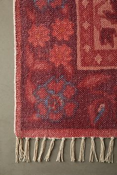 a red rug with fringes on top of it