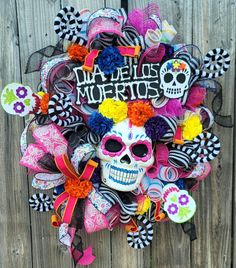 a wreath made to look like a skeleton with colorful hair and makeup on it that says dia de los muertos