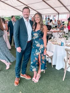 a man and woman standing next to each other under a tent