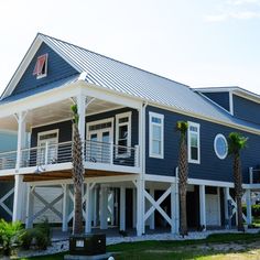 a blue house with white trim and palm trees