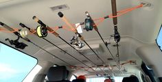 there are many fishing rods hanging from the ceiling in this vehicle's cargo area