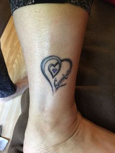 a woman's foot with a heart tattoo on it