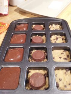 a muffin tray with chocolate chip cookies and cupcakes in it on a table