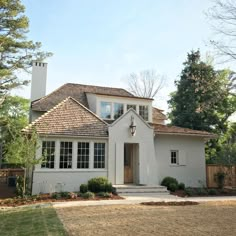 a white house with brown shingles on the roof