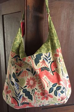 a purse hanging on a door handle in front of a wooden paneled door with floral designs